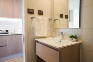 Chuveiro, secador de cabelo, toalhas de banho, shampoo