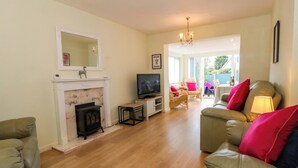 A living room with a fireplace, television, and seating area. - The Warren (Chester)