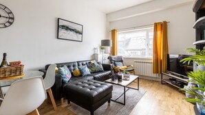 Een moderne woonkamer met een bank, salontafel en een televisie.