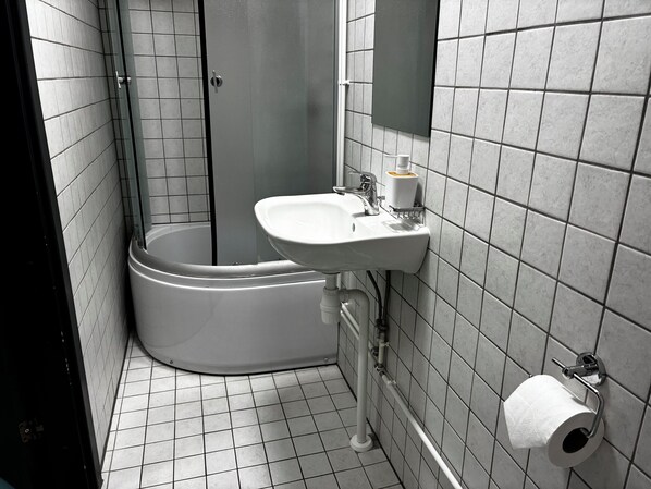 Een badkamer met toilet, wastafel en douche.