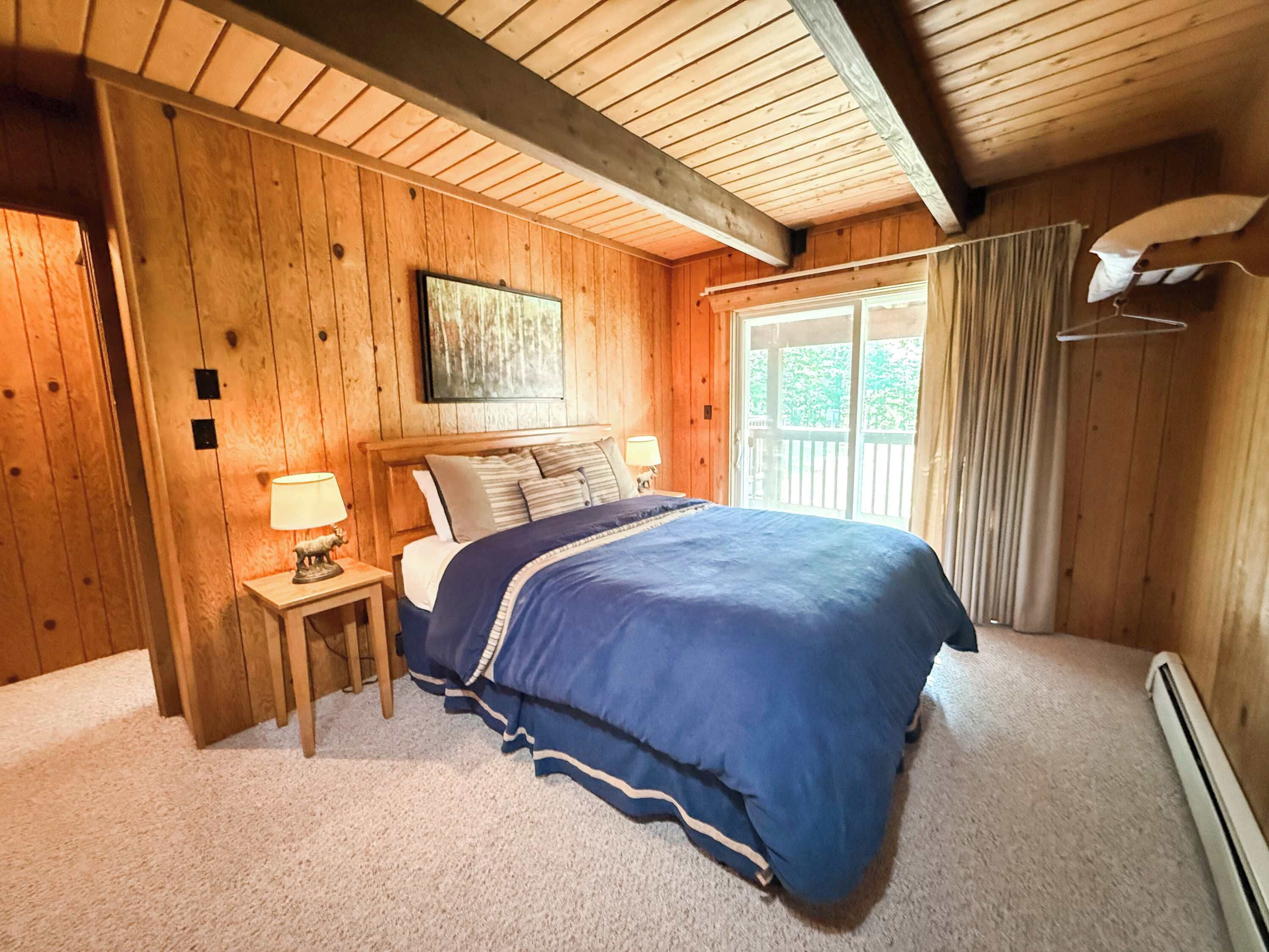 This queen bedroom also has a clothing bar, two luggage racks and a sliding glass door onto the back deck. 