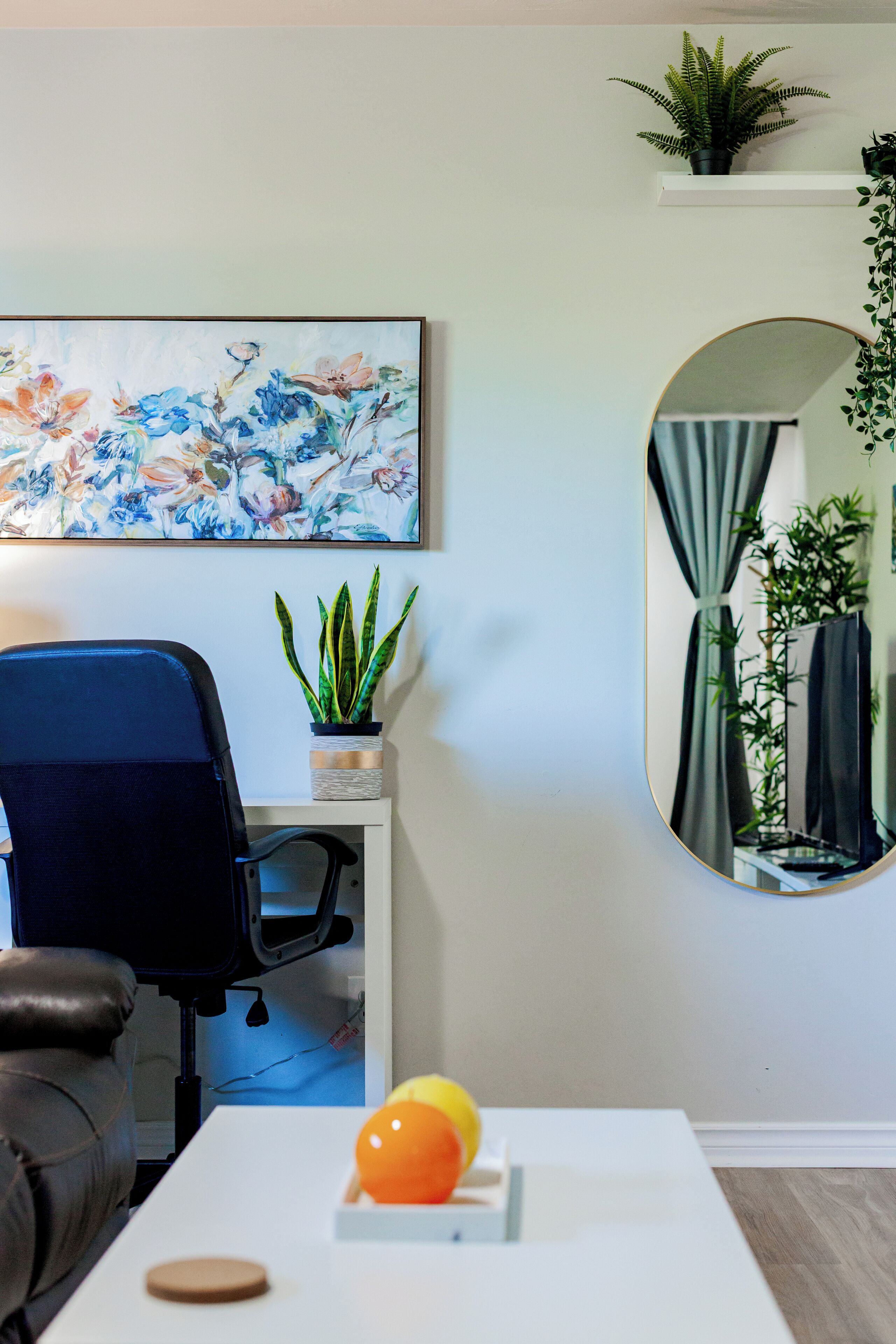 A modern office space with a desk, chair, and a potted plant.