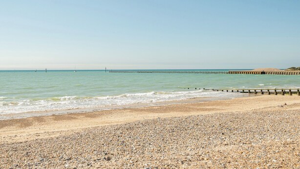 A pebbly beach with a wooden pier extending into the water. - Marine Court First-floor Double Bedroom With Wet Room (Littlehampton)