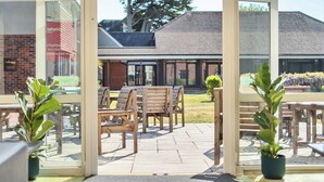 An outdoor seating area with wooden benches and potted plants. - Marine Court First-floor Double Bedroom With Wet Room (Littlehampton)