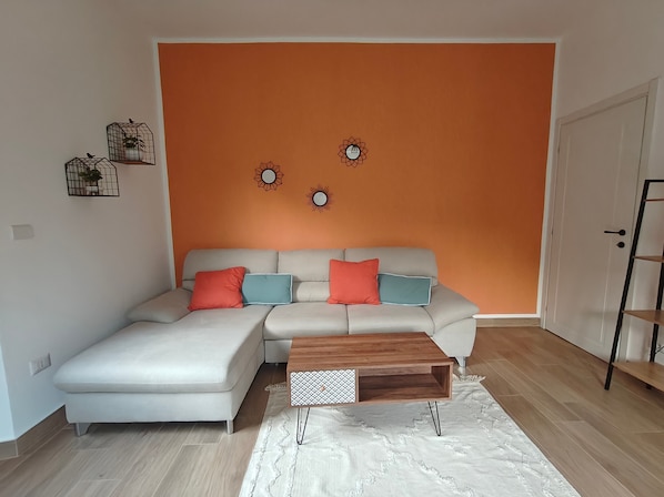 A modern living room with a sectional sofa, a wooden coffee table, and decorative wall art.