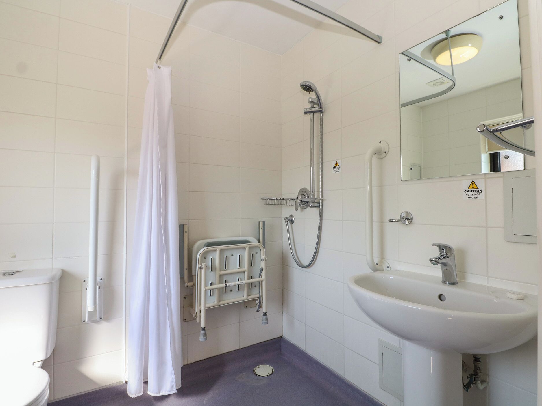 A bathroom with a shower, toilet, and sink.
