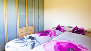 A bedroom with a bed, a wardrobe, and a nightstand.