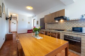 Une cuisine moderne avec des meubles en bois, un four à micro-ondes encastré et une cuisinière.