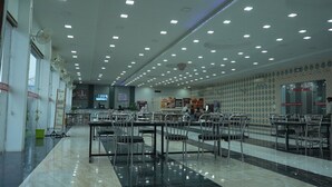 A spacious hotel lobby with multiple dining tables and chairs, a reception desk, and a Family Hall sign. - Hotel Holiday Fun Resort (Kotputli)