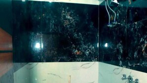 Un baño pequeño con inodoro, lavamanos y un balde.