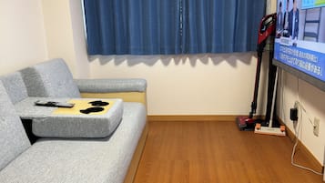 Apartamento família, 2 quartos, sacada | Área de estar | TV LCD 43 polegadas com canais a cabo, livros