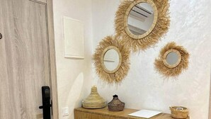 A wooden desk with a mirror, a woven basket, and a small vase. - Sérénité Orientale I Apartment in Marrakech (Marrakesh)