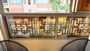 A balcony with two black wire-framed chairs, a small round table, and a decorative screen. - Sérénité Orientale I Apartment in Marrakech (Marrakesh)