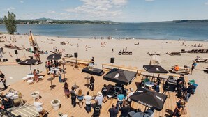 Una location sul lungomare con posti a sedere all'aperto, ombrelloni e un palco per eventi.