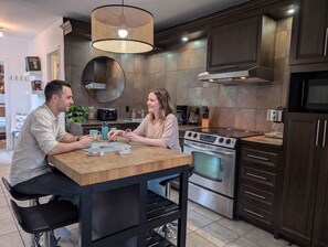 Une cuisine entièrement équipée avec un îlot convivial, parfaite pour cuisiner, prendre un café ou s'amuser ensemble.