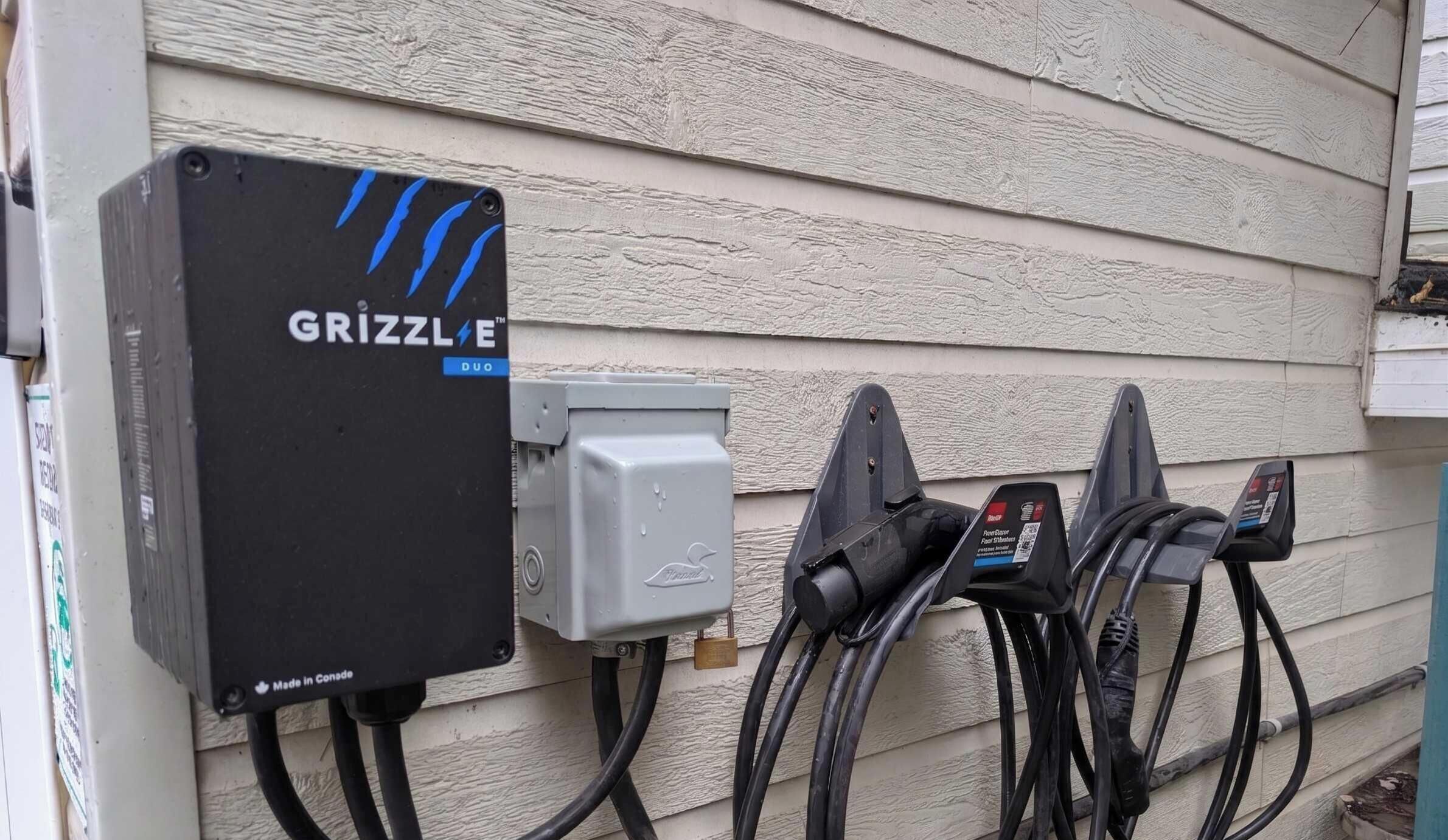 Caja de medidor de servicios con la etiqueta 'GRIZZLE', un candado y varios cables conectados.