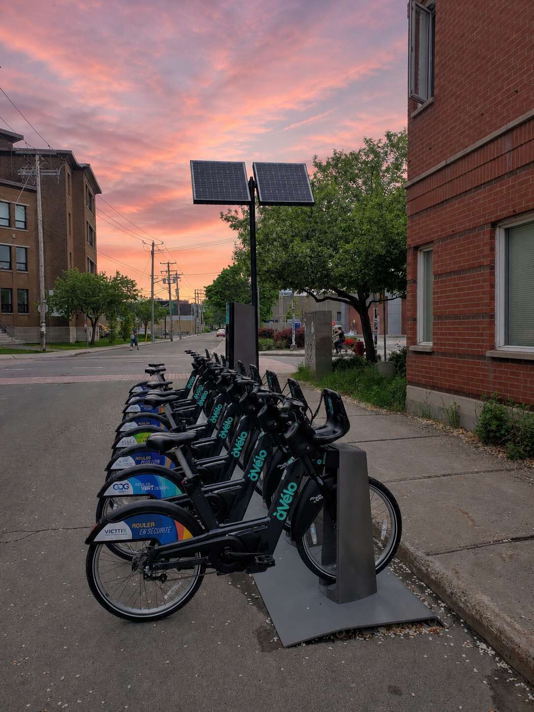 Une station de vélos en libre-service où plusieurs vélos sont stationnés dans un environnement urbain.