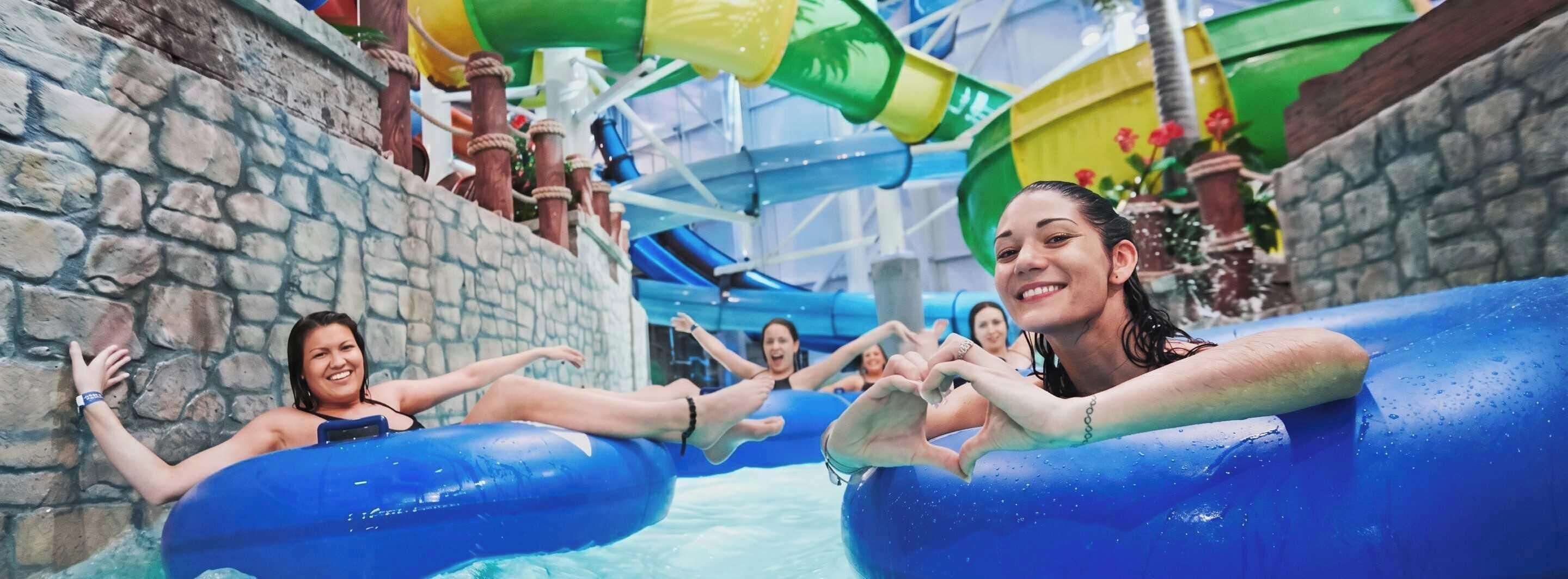 An indoor water park with water slides and inflatable tubes.