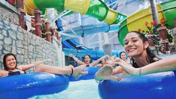 An indoor water park with water slides and inflatable tubes.