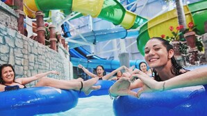 A water park with inflatable tubes and a stone wall.
