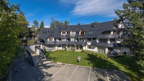 A large, multi-story building with a curved roofline, multiple balconies, and a well-maintained lawn. - Bogdanskiego Residence Sun Snow (Zakopane)