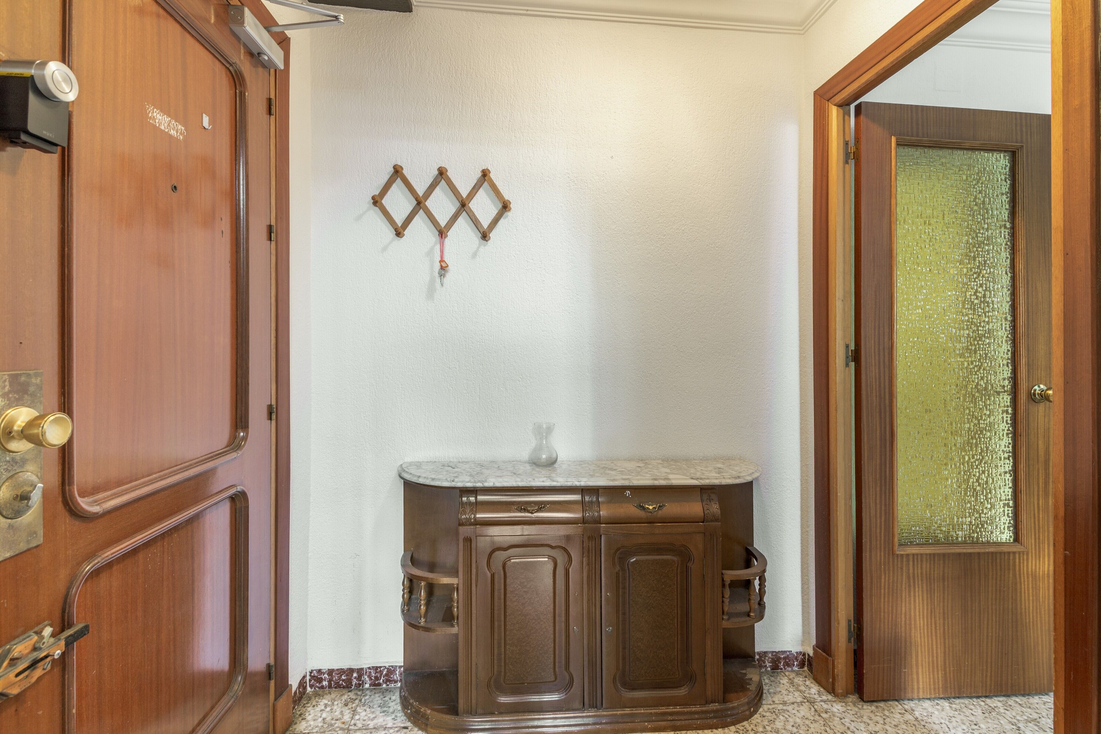 Una habitación con puerta de madera, encimera de mármol y un adorno en la pared.