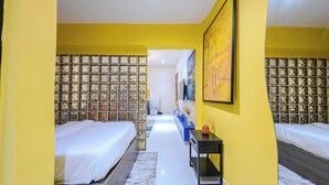 A hotel room with two beds, a large window with a view, a desk with a vase, and a painting on the wall. - Glassvine (Lagos)