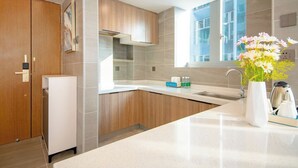 A modern kitchen with a built-in oven, a sink, and a window providing natural light. - Wisdom Forest Hotel (Shenzhen)