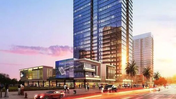 A modern high-rise building with a glass facade, surrounded by palm trees and a busy street with cars. - Wisdom Forest Hotel (Shenzhen)