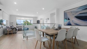 Ein modernes Interieur mit Essbereich, einer Couch und einem großen, abstrakten Gemälde.