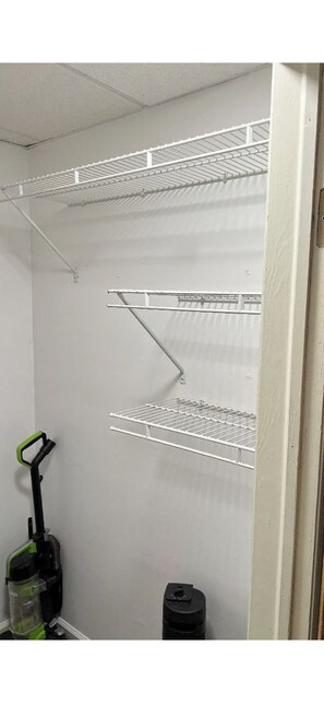 Een kamer met witte schapenkasten, een stofzuiger en een prullenbak.