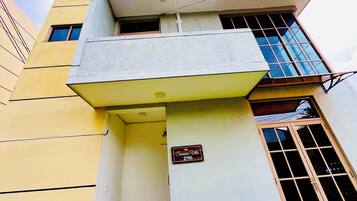 Edifici amb façana groga, un rètol que diu "Samara Villa 29B" i una finestra amb un disseny de reixeta.