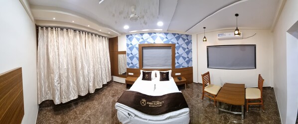 Une chambre d’hôtel comprenant un lit, une table à manger avec des chaises, une grande fenêtre et un climatiseur fixé au mur.