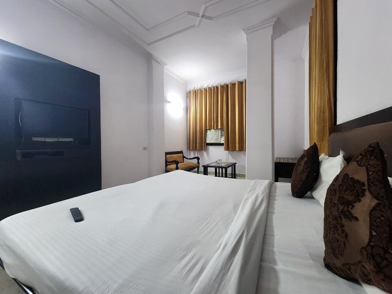 Hotellihuone, jossa on suuri sänky, työpöytä, tuoli ja vaatekaappi.