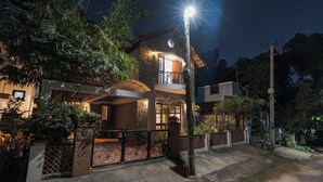 Een huis met twee verdiepingen, een balkon, een poort en een lantaarn.