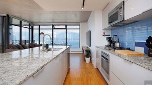 Una cocina moderna con una isla grande, electrodomésticos de acero inoxidable y vistas a la ciudad.