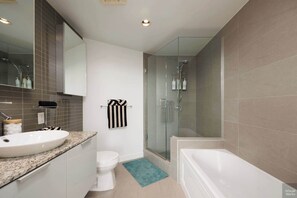 A modern bathroom with a large sink, toilet, glass shower enclosure, and a bathtub. - Elegant 2-Bedroom Condo in Vancouver (Vancouver)