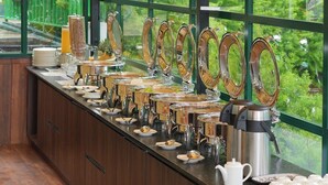 A buffet setup with multiple self-service stations, including hot and cold food options, and a coffee machine. - Gardenia Kanthalloor by VOYE HOMES (Devikolam)