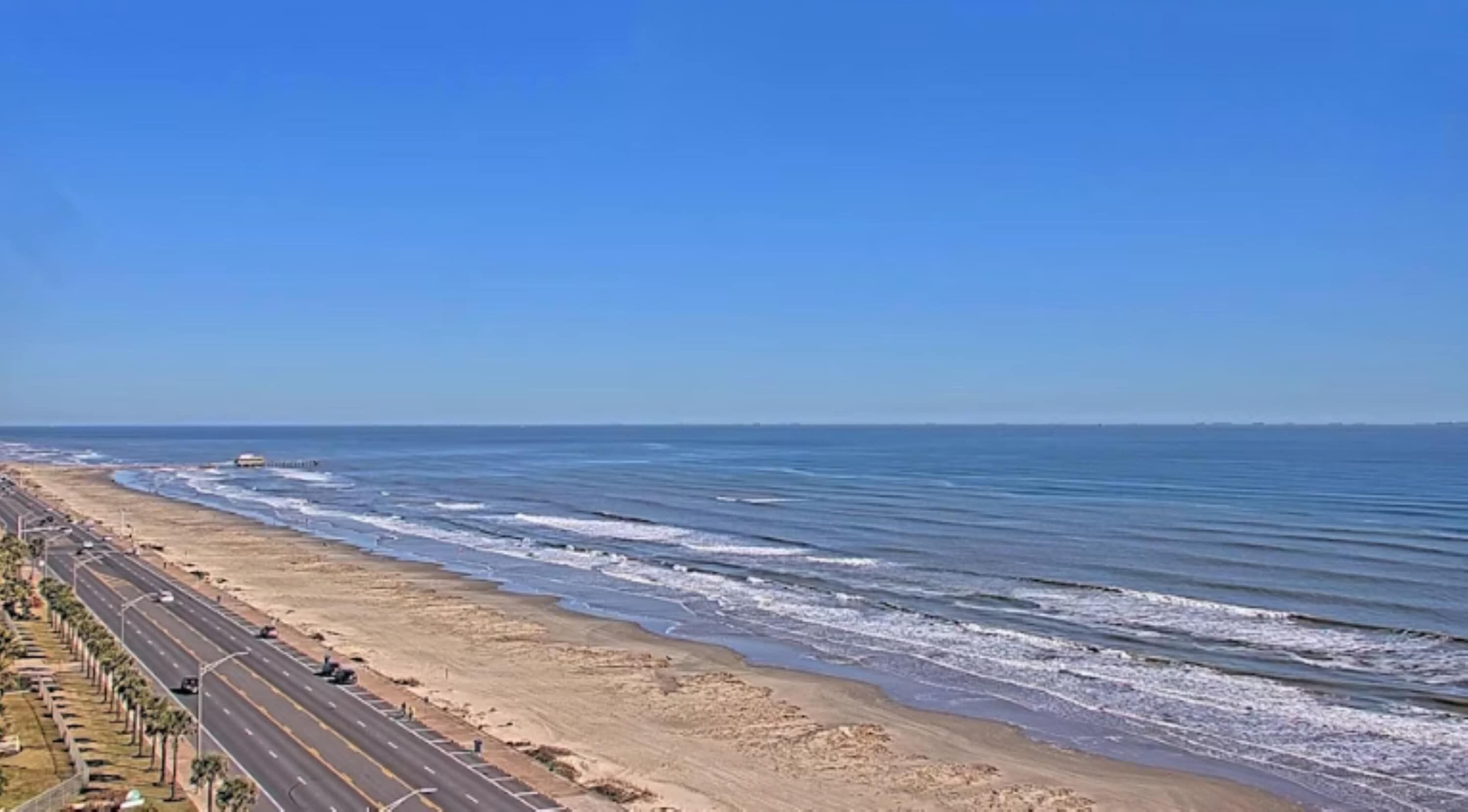 A coastal road with a beach and ocean.