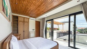 A bedroom with a wooden ceiling, a large bed, a wardrobe, and a sliding glass door leading to a balcony with a view of the sea. - 2-bedroom Villa Athaya in peaceful Bali (Bali)
