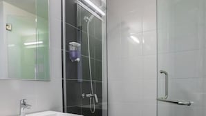 A modern bathroom with a white sink, a glass-enclosed shower, and a handrail on the door. - KL2F Empire Hotel  Empire (Malacca City)
