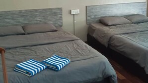A hotel room with two beds, a wall-mounted light fixture, and a framed picture. - KL2F Empire Hotel  Empire (Malacca City)