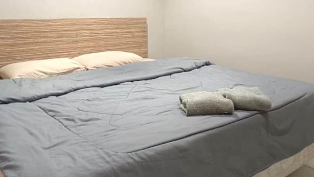 A bedroom with a bed, pillows, and a folded towel. - KL2F Empire Hotel  Empire (Malacca City)