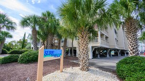A sign for a 'Sea Walk' path, palm trees, and a building with a covered walkway. - Surfwalk 343 – Shared Pool, 2 Balconies & Easy Beach Access (Surfside Beach)