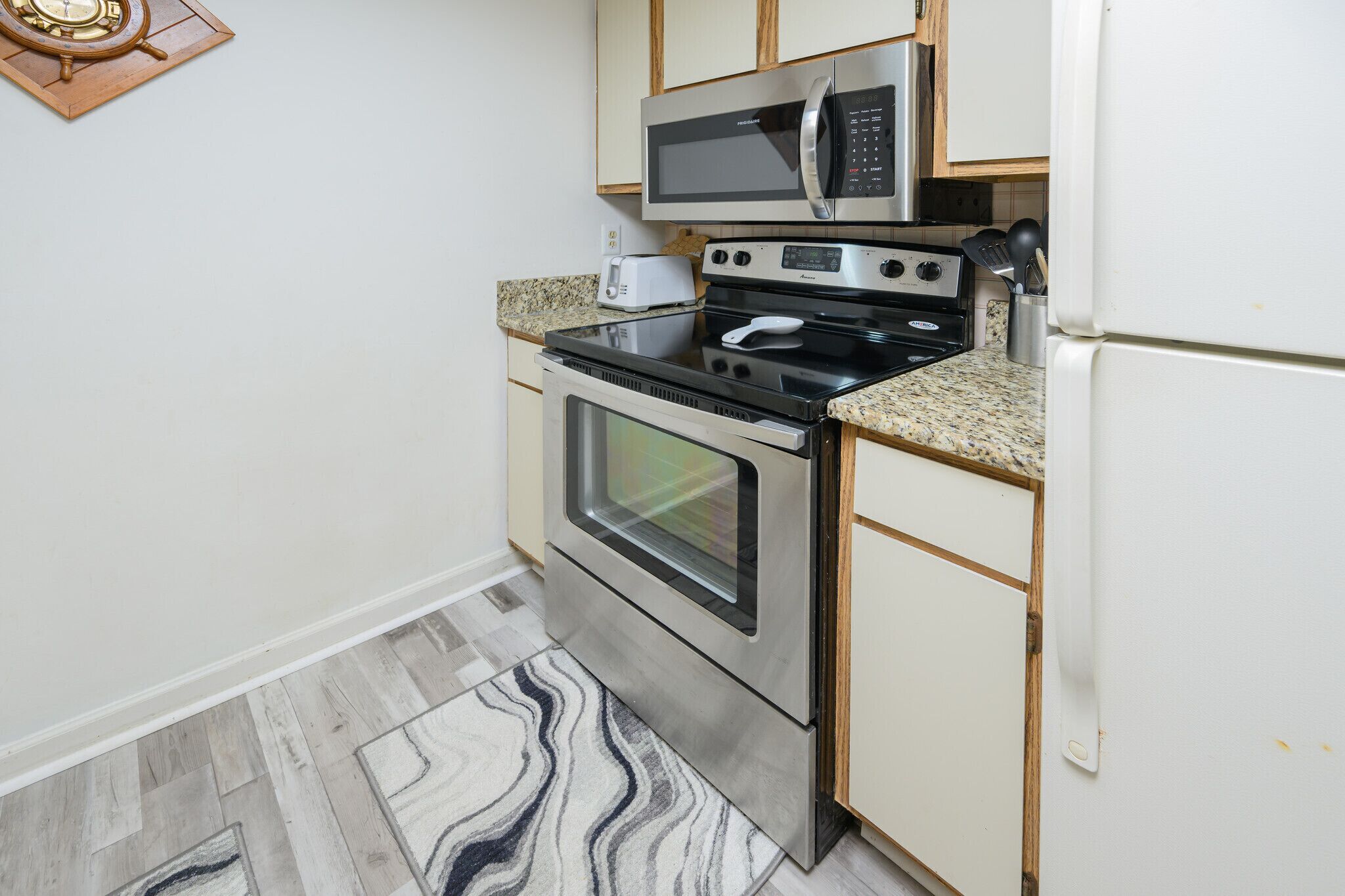 Una cocina compacta con microondas, horno y cocina empotrados.