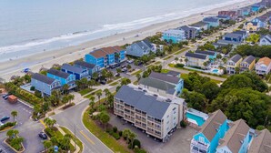 An aerial view of a coastal residential area with houses, a beach, and a pier. - Surfwalk 343 – Shared Pool, 2 Balconies & Easy Beach Access (Surfside Beach)