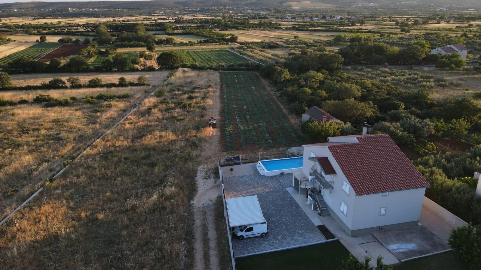 Una propiedad residencial con piscina, garaje independiente y un amplio jardín.