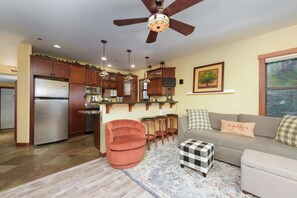 A modern kitchen with a central island, wooden cabinets, and a ceiling fan. - A Modern Condo With Amazing Sunsets (SL313#11) (Stateline)