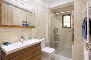 Ein Badezimmer mit großem Spiegel, Waschbecken, Toilette und einer Duschkabine.