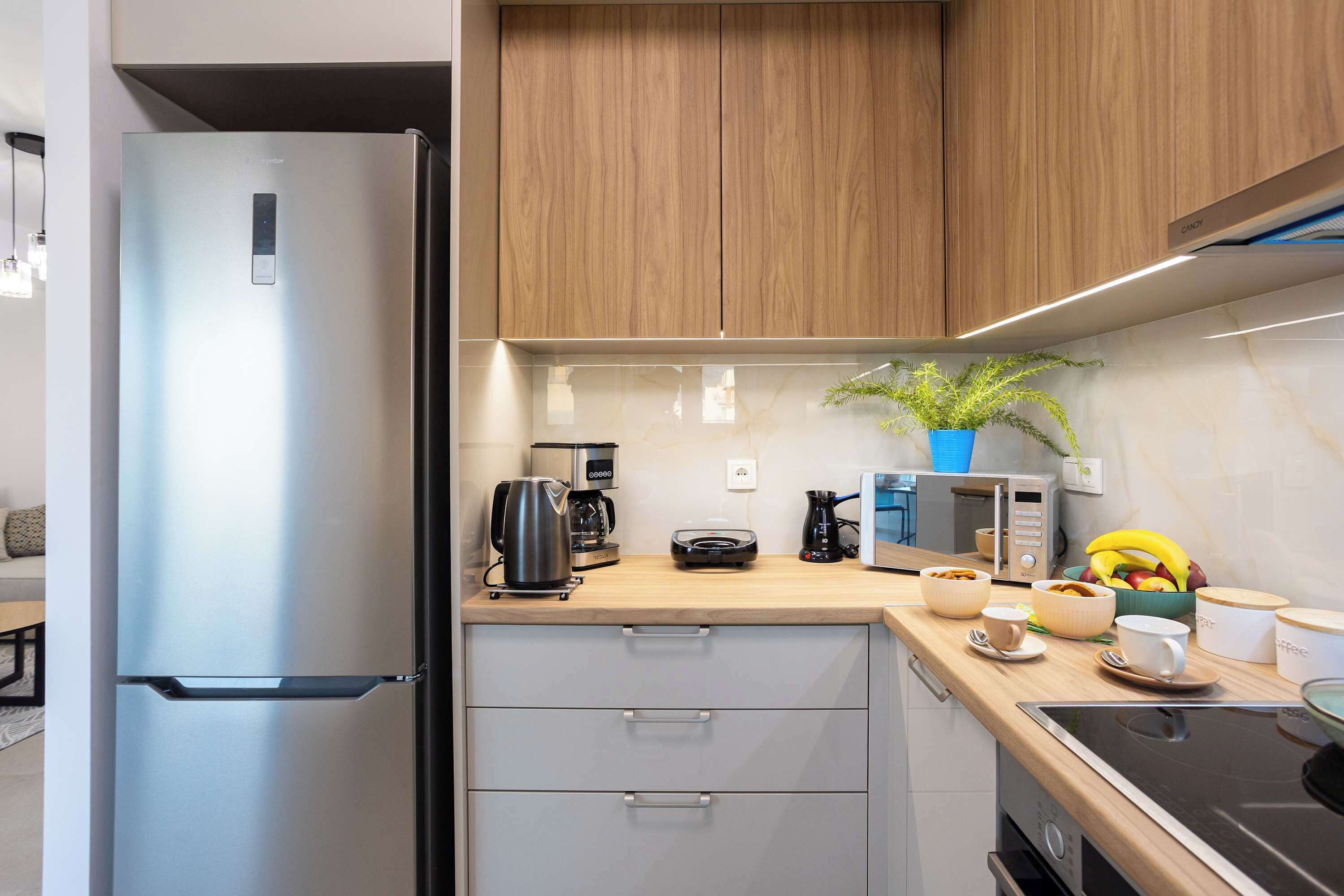 A modern kitchen with a built-in refrigerator, a coffee maker, a microwave, and a stove.